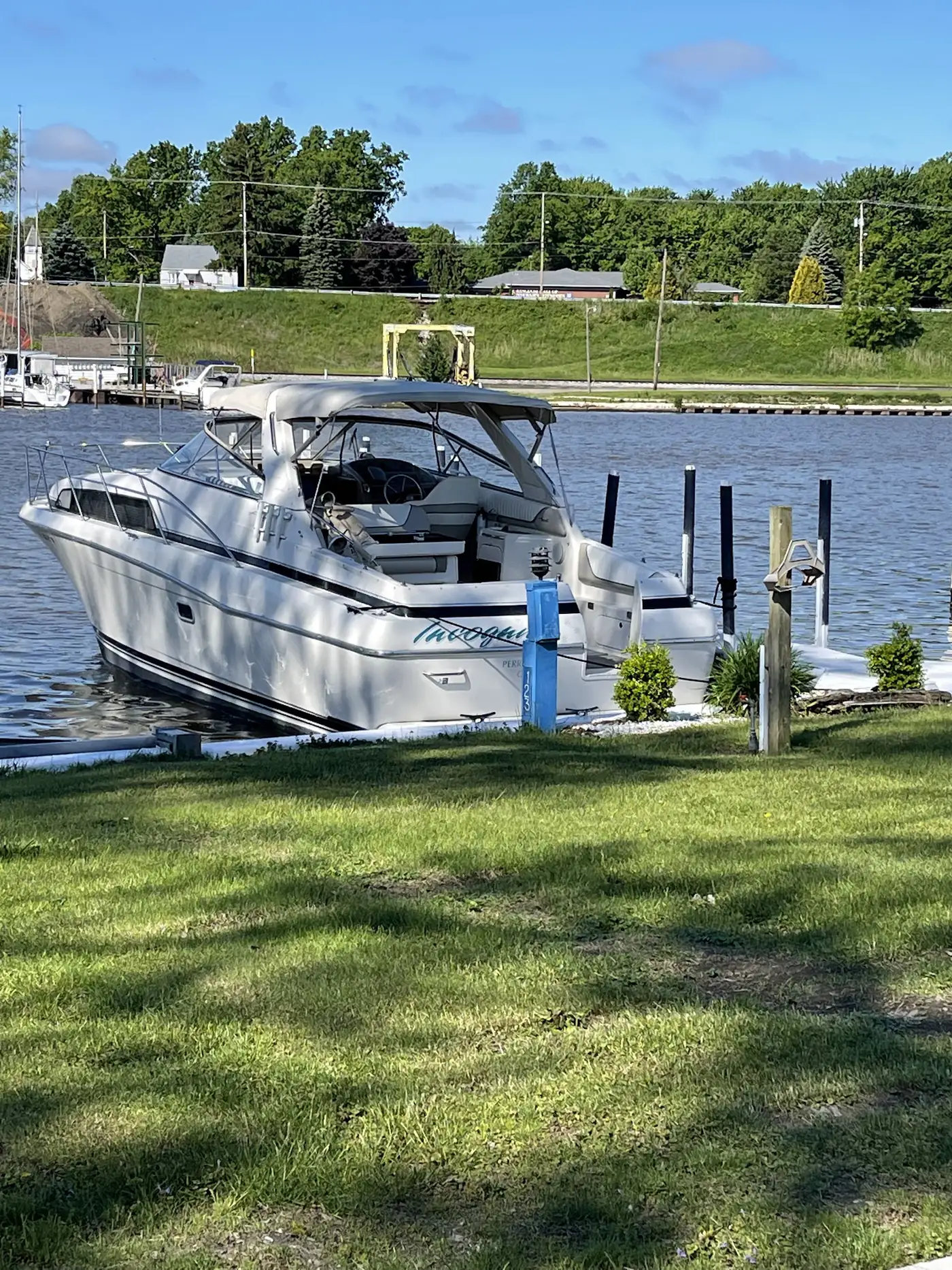 A powerboat tied up at a grassy FHYC slip on the Grand River